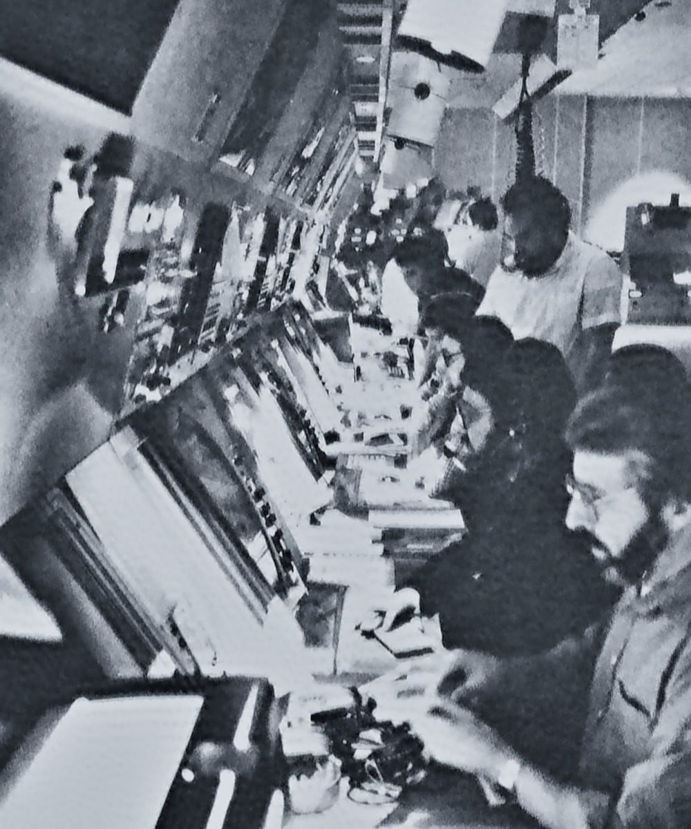 FAA air traffic controllers seated along a row of Sperry Univac ARTS IIIA Type I DEDS (FA-8320) radar consoles inside the New York TRACON facility on Long Island.
